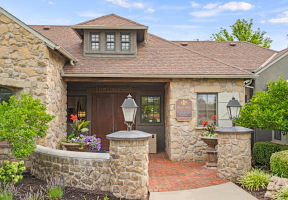 a home with stone walls and a brown door at Avignon Apartment Homes, Olathe, KS