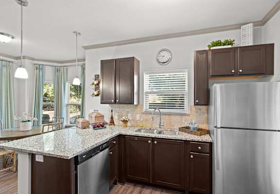 A kitchen with brown cabinets and a granite countertop.