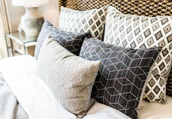 a pile of pillows on top of a bed