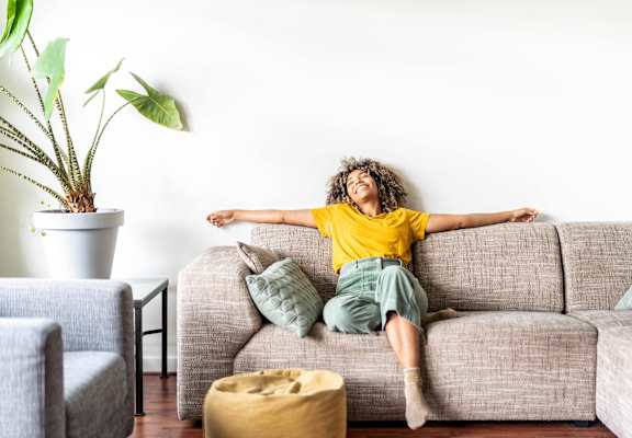 a woman laying on a couch with her arms stretched out