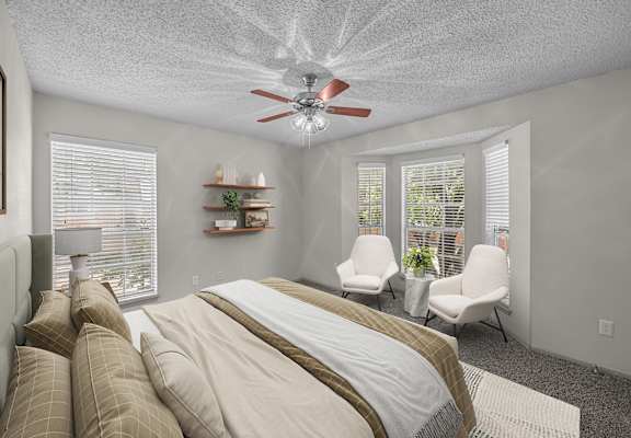 A bedroom with a large bed and a ceiling fan.