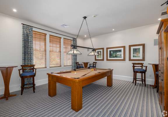 A room with a pool table and a chair.