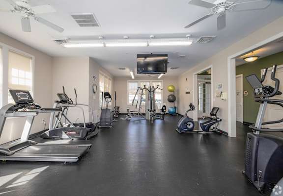 A spacious gym with treadmills, elliptical machines, and other exercise equipment.