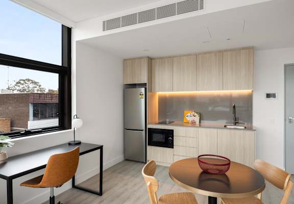 A modern kitchen with a table and chairs.
