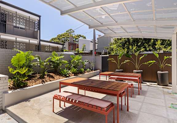 A patio with a table and chairs under a white awning.