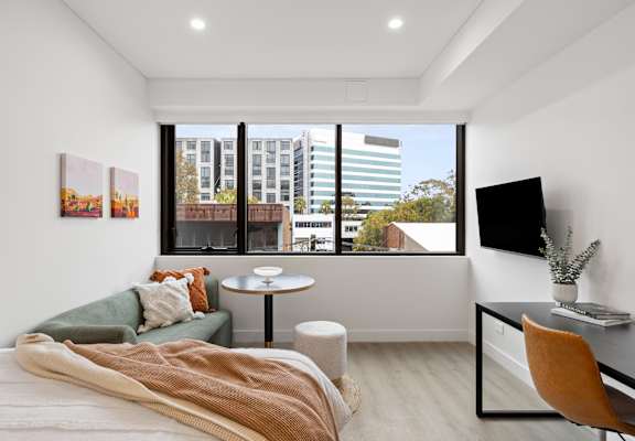 A bedroom with a bed, desk, and chair.
