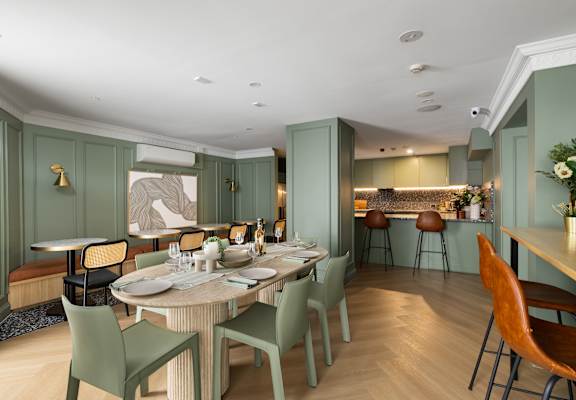 A dining room with a table set for a meal.