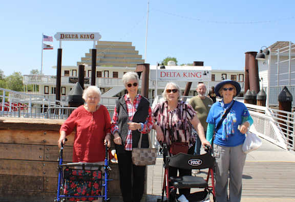 A group of people are standing in front of a Delta King sign.