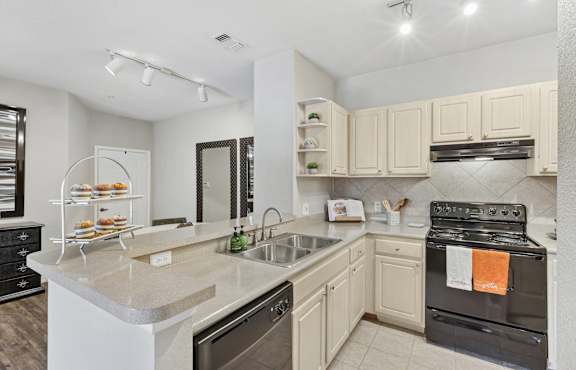 A kitchen with a black oven and white cabinets.