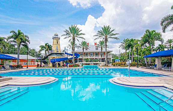 A large swimming pool with a lighthouse in the background.