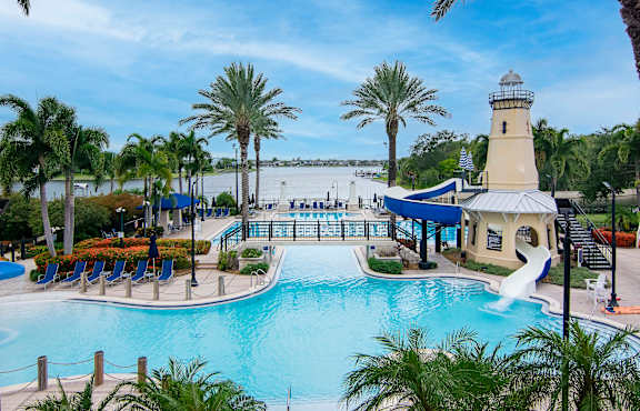 A pool with a water slide and a lighthouse.