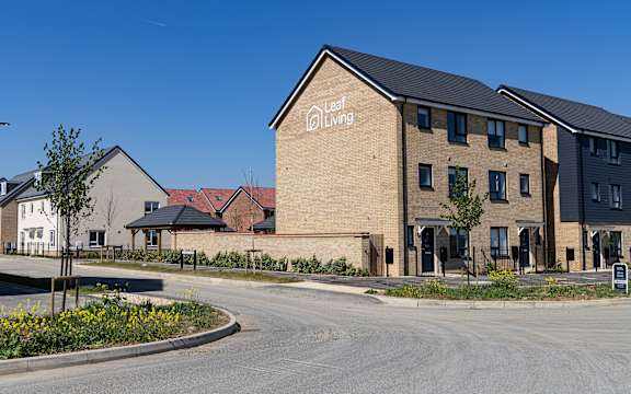 A Leaf Living residential building with a clear blue sky in the background.