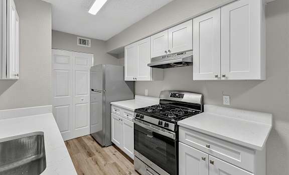 A kitchen with white cabinets and stainless steel appliances.