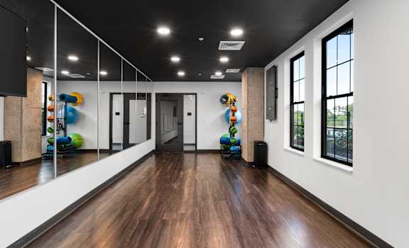 a large room with a hard wood floor and mirrors