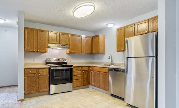 A kitchen with wooden cabinets and stainless steel appliances.