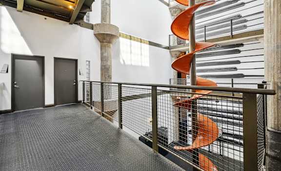 a spiral staircase in a building with a orange spiral art installation