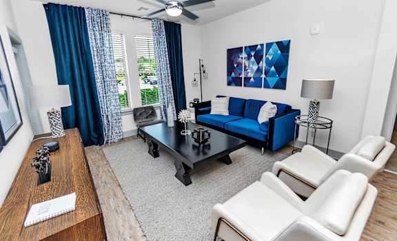 a living room with a blue couch and a black coffee table at CODA Apartments , Florida, 32826