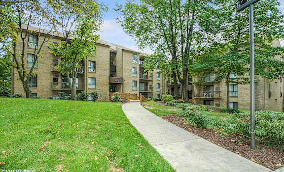 A grassy area in front of apartment buildings.