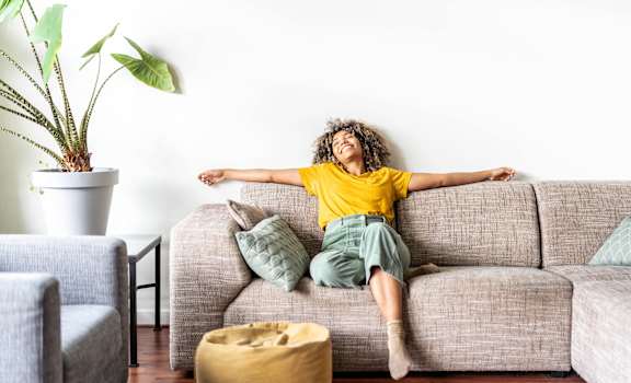 a woman laying on a couch with her arms stretched out