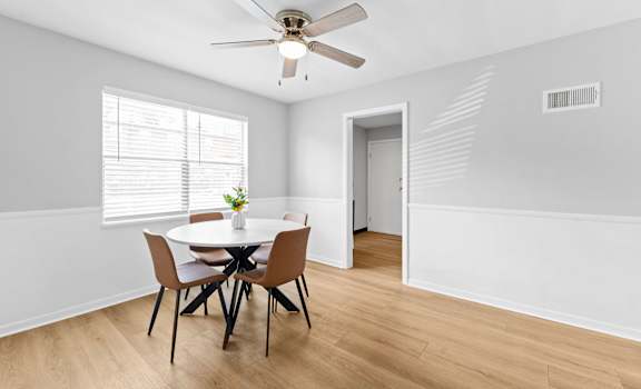 A dining room with a table and chairs.