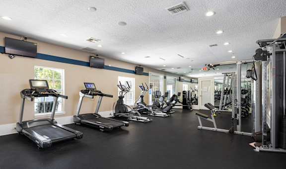 A gym with treadmills, exercise bikes, and other equipment.