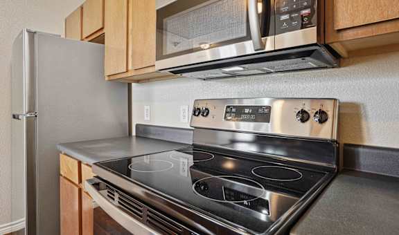 A modern kitchen with a stainless steel stove and microwave above it.