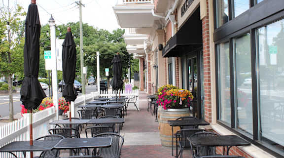a patio with tables and chairs outside of a building