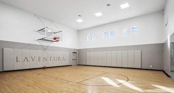 the gym has a hardwood floor and a basketball court at La Ventura Apartments, Texas