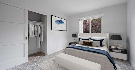 A bedroom with a large bed and a painting on the wall.