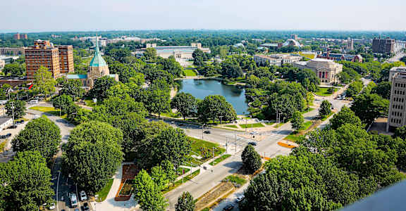 A cityscape with a large green park in the middle.