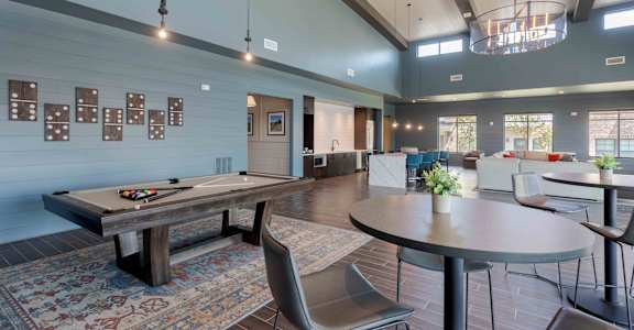A room with a pool table and a billiard table.