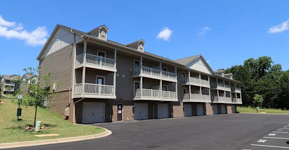 A large apartment complex with a parking lot in front.