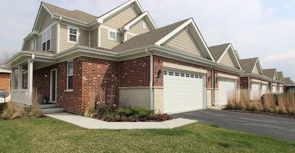 a brick house with a white garage door in front of it
