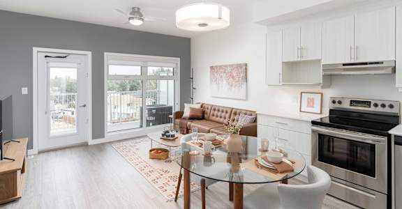 A modern kitchen with a glass table and a sofa.