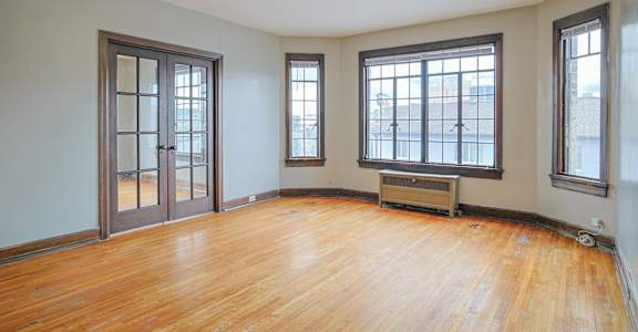 A room with a wooden floor and a ceiling fan.