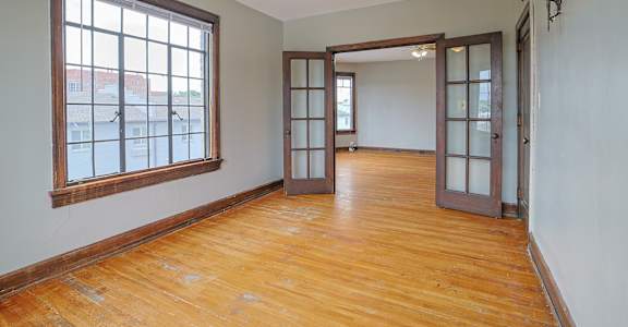 A room with wooden floors and a ceiling fan.