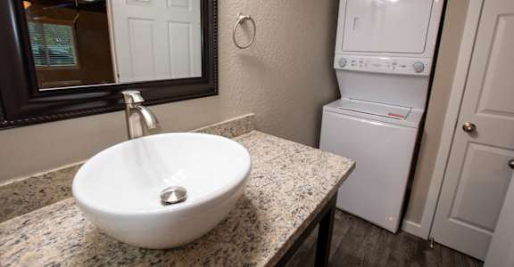 bathroom with vanity and stacked washer dryer