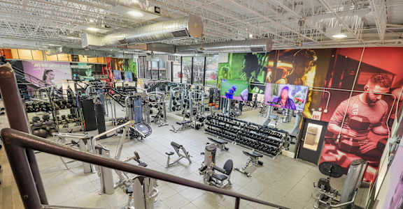 A gym with a variety of equipment including treadmills, weights, and exercise machines.