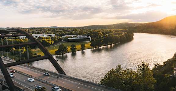 A bridge over a river with cars driving on it.