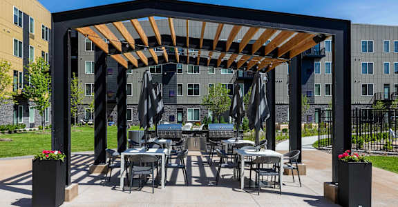 a patio with tables and chairs and awning