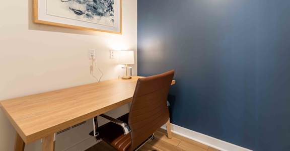 a home office with a wooden desk and a blue wall