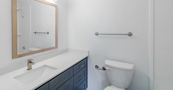A white toilet sits next to a sink in a bathroom.