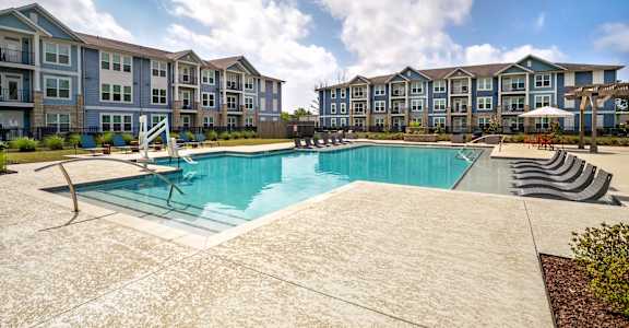 A large swimming pool in front of apartment buildings.