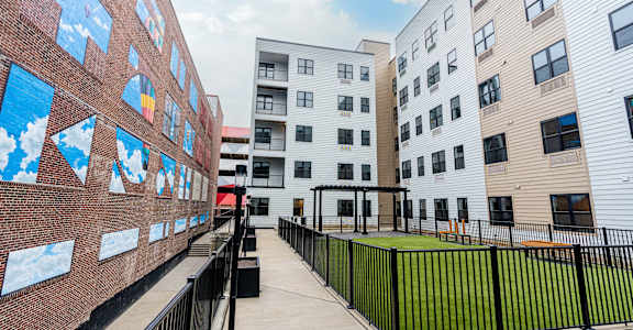A long corridor with a black fence and a wall with pictures on it at The Gallery Apartment Homes Apartments, Allentown, PA, 18101