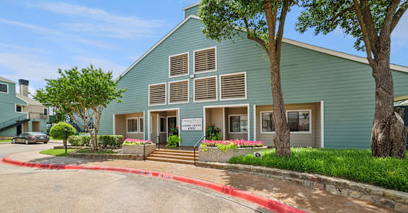 A green building with a red curb in front of it.