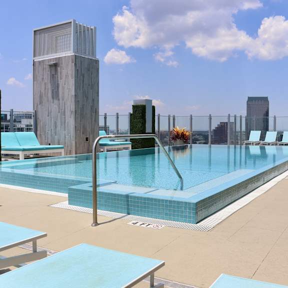 the pool at the top of a hotel overlooking the city