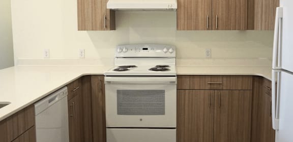 A white stove top oven with a white refrigerator in a kitchen.