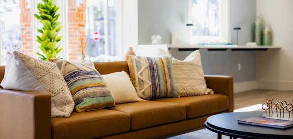 A brown couch with striped pillows sits in a living room.