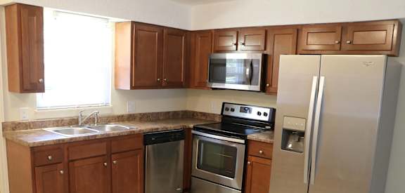 a kitchen with stainless steel appliances and wooden cabinets