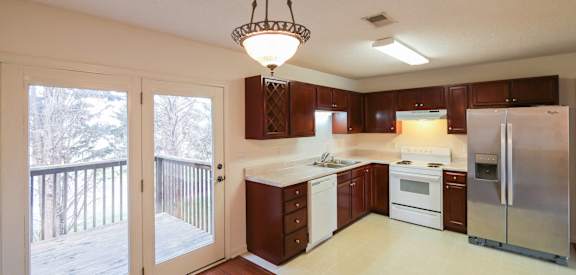 a kitchen with a sliding glass door to a balcony